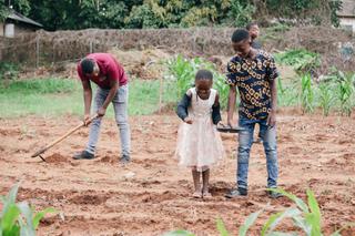 Children learning how to plant seeds at our vegetable gardens