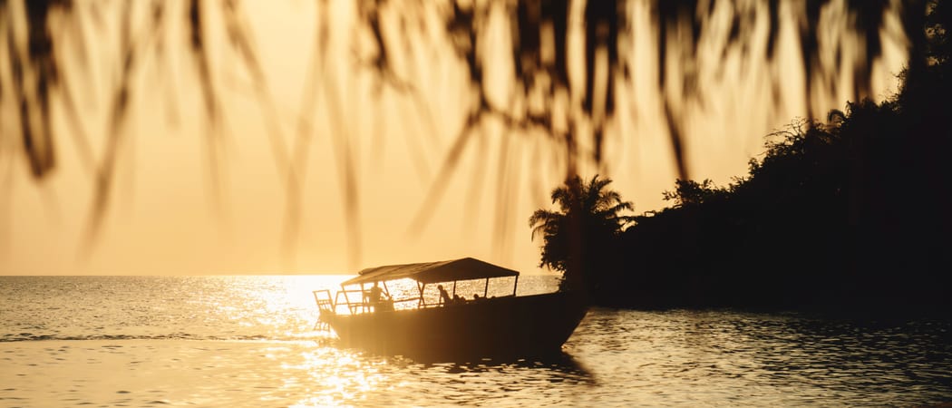 Dhow moored off the beach as the sun sets on Lake Tanganyika Original