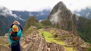 Female tourist gesturing a love sign to the famous ancient Inca ruins of Machu Picchu Cusco Peru Canva Pro Female tourist gesturing a love sign to the famous ancient Inca ruins of Machu Picchu Cusco Peru Canva Pro