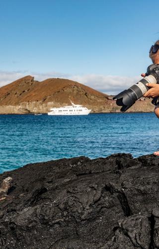 Tourist photographing marine iguana in the Galapagos Ecuador