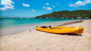Yellow kayak on white sand beach of Bequia St Vincent and the Grenadines Canva Pro Yellow kayak on white sand beach of Bequia St Vincent and the Grenadines Canva Pro