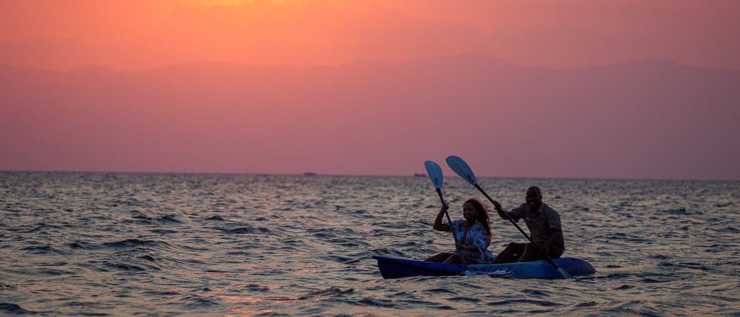 Couple kayaking at sunset Pumulani lodge malawi wetu
