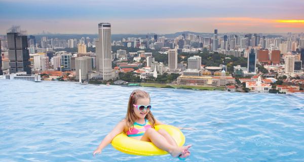 Child in pool overlooking Singapore skyline
